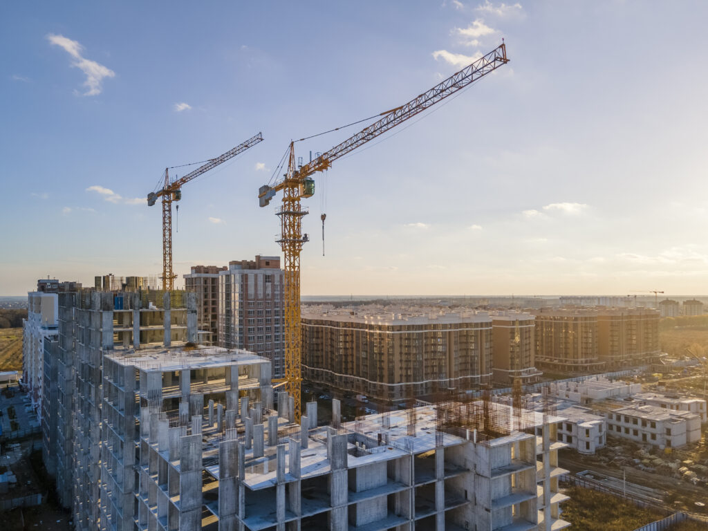 Cranes on the construction site surrounded by new real estates